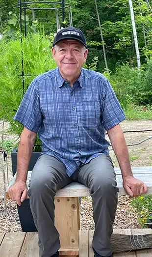 Photo of Michael Engler smiling, sitting on a bench